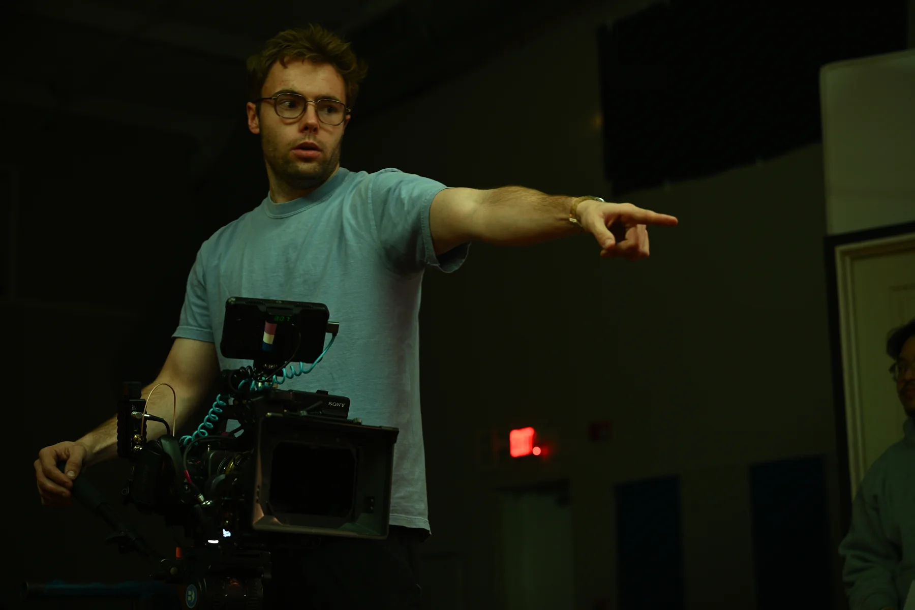 A crew member coordinates a shot beside the camera.