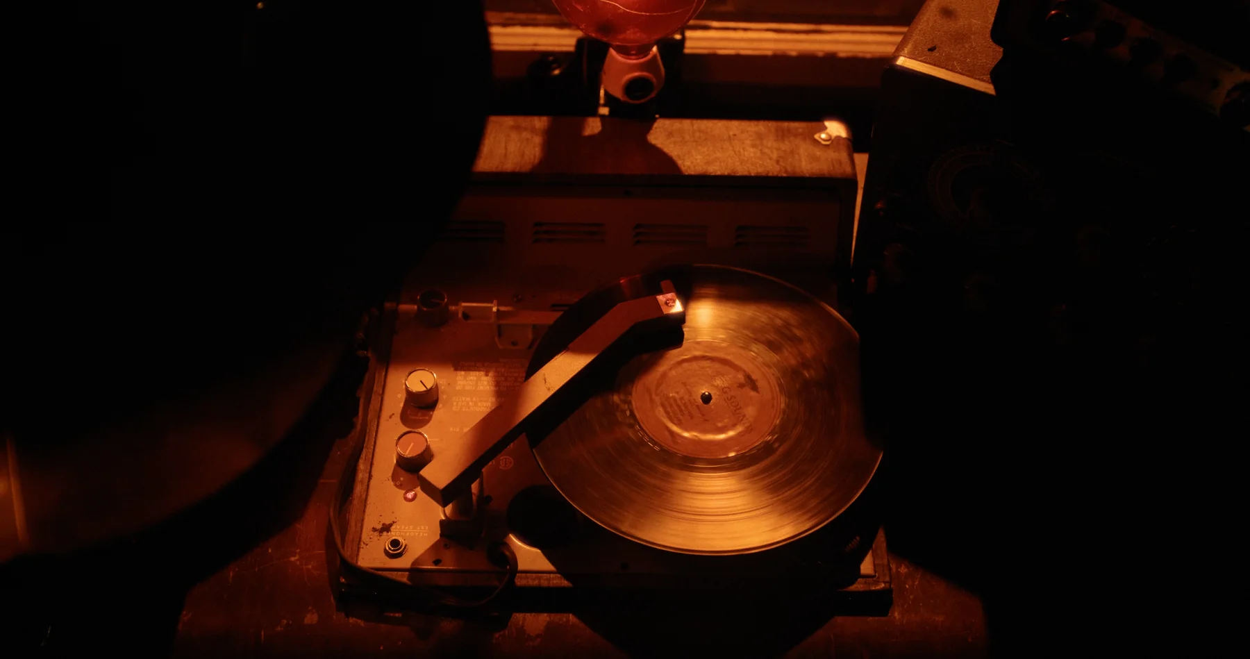 A record spins on a warmly lit turntable.